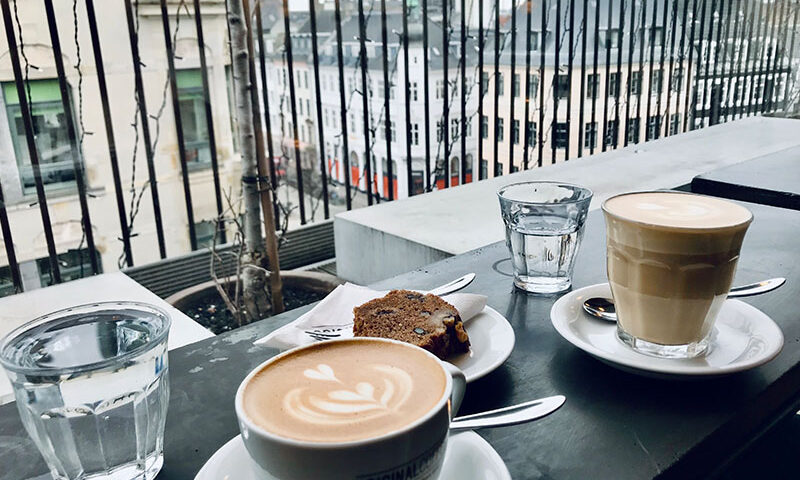 כוסות קפה ועוגות במרפסת בבית קפה בקופנהאגן