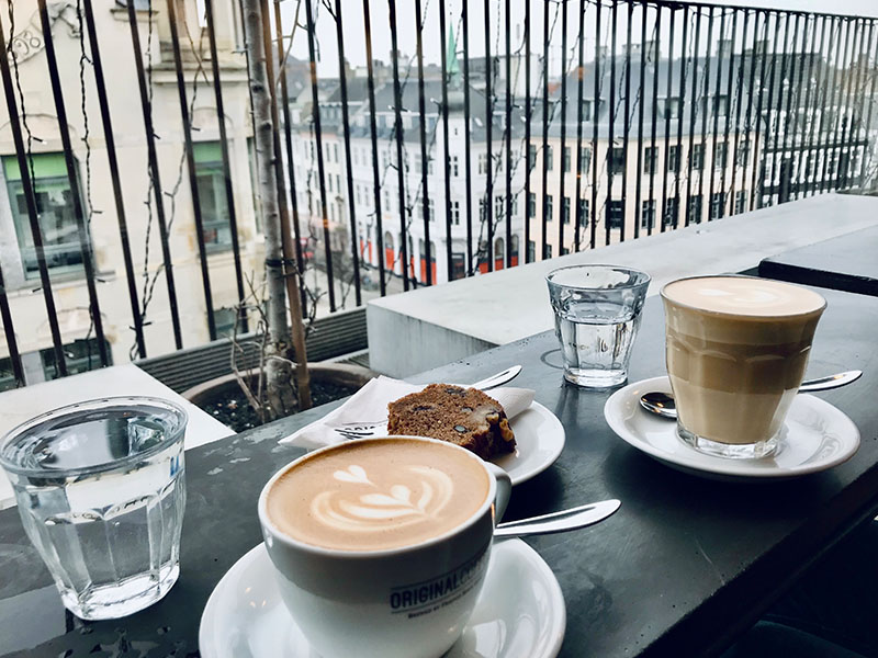 כוסות קפה ועוגות במרפסת בבית קפה בקופנהאגן