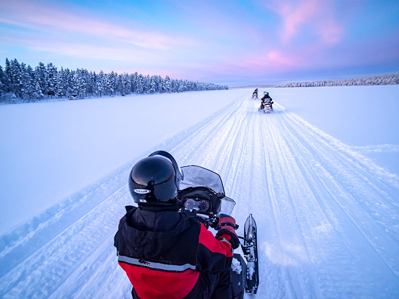 אופנועי שלג על הקרח וברקע הזוהר הצפוני